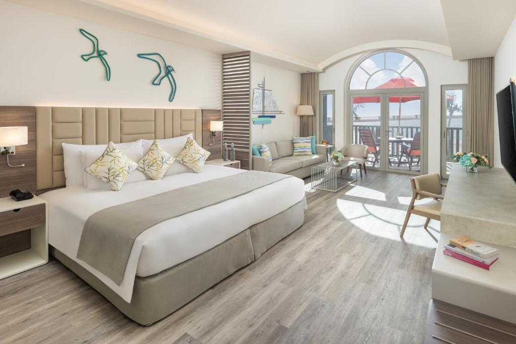 a bedroom with a large bed and a living room at JA Palm Tree Court, Dubai in Dubai