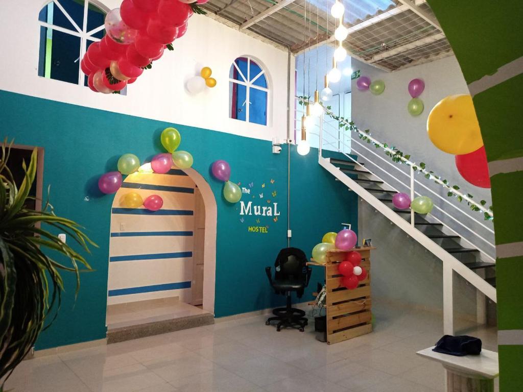 a room with a staircase and balloons on the wall at The Mural Hostel Bogotá in Bogotá