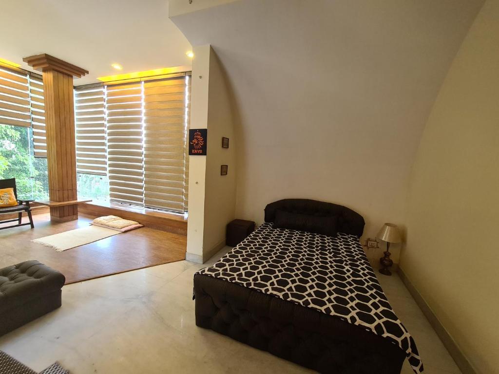 1 dormitorio con cama y ventana grande en Lychee Bungalow en Dehradun