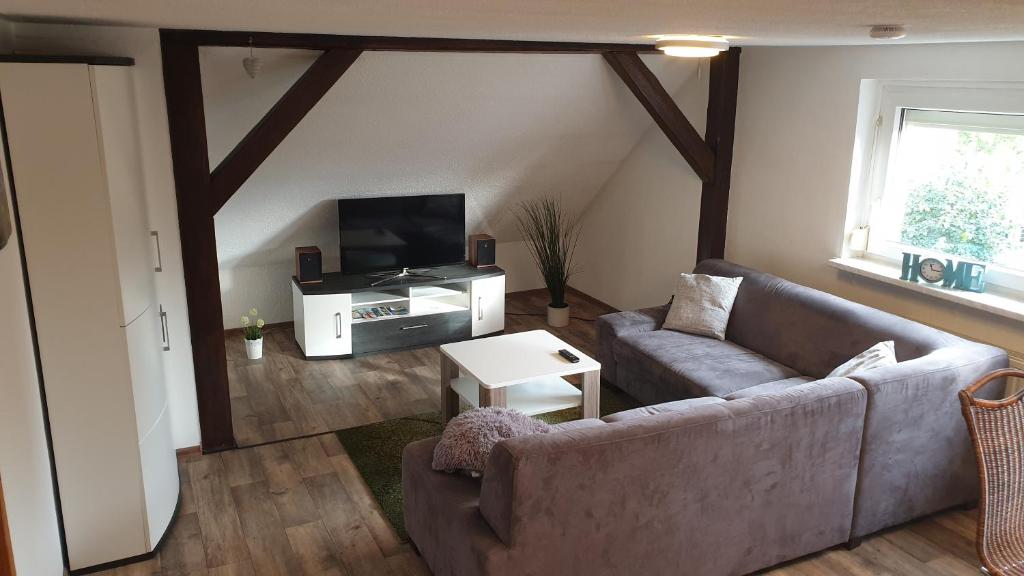 uma sala de estar com um sofá e uma televisão em HässelHof - 80qm Ferienwohnung im Zentrum von Bad Liebenwerda em Bad Liebenwerda