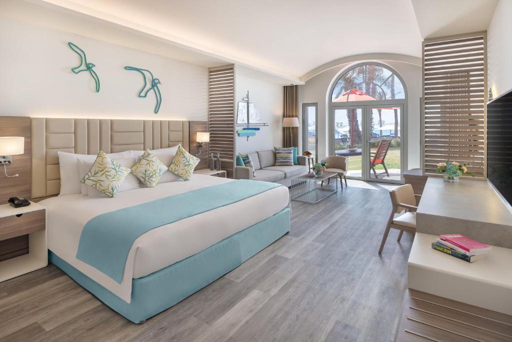 a bedroom with a bed and a living room at JA Palm Tree Court, Dubai in Dubai