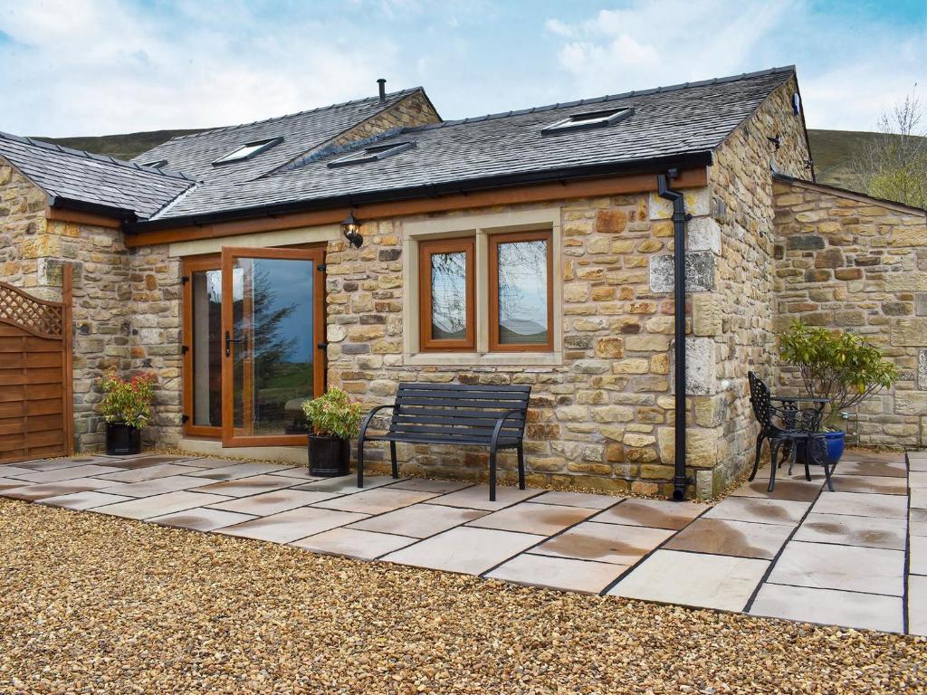 a stone cottage with a bench in front of it at Roosters Rest - Uk31826 in Rimington