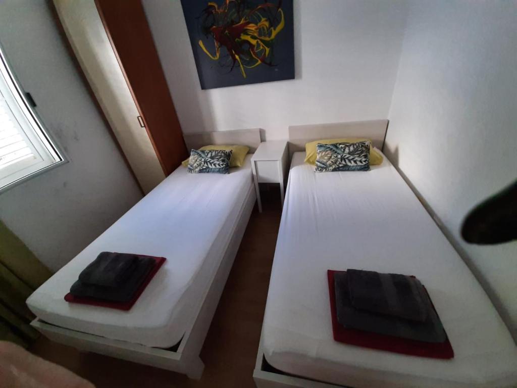 two beds in a small room with a window at Seafront Suites Maja in Vis