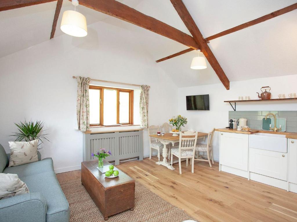 a living room with a table and a kitchen at The Hayloft - Uk32686 in Sheepstor