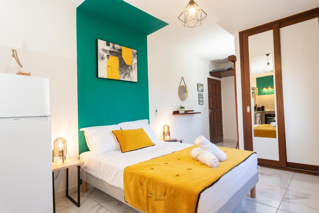 1 dormitorio con 1 cama con pared verde en Le Jardin Secret Guyanais avec Piscine et Jardin de 70 m2, en Cayenne