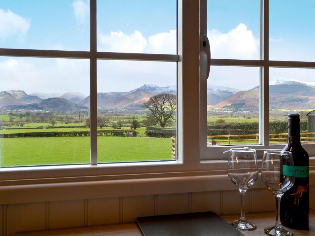 a window with two wine glasses and a view of mountains at Derwent - Uk1406 in Applethwaite