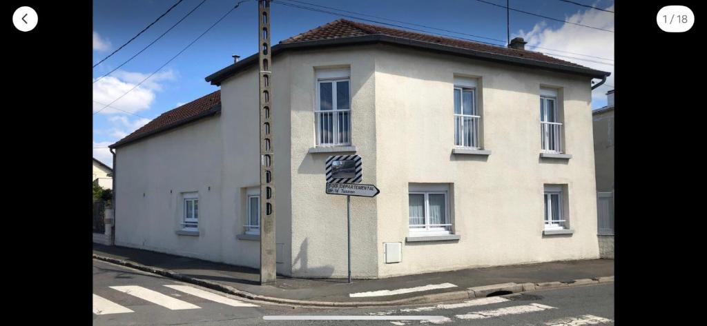 un bâtiment blanc avec un panneau de rue devant lui dans l'établissement Jolie Studio spacieux, à Villepinte