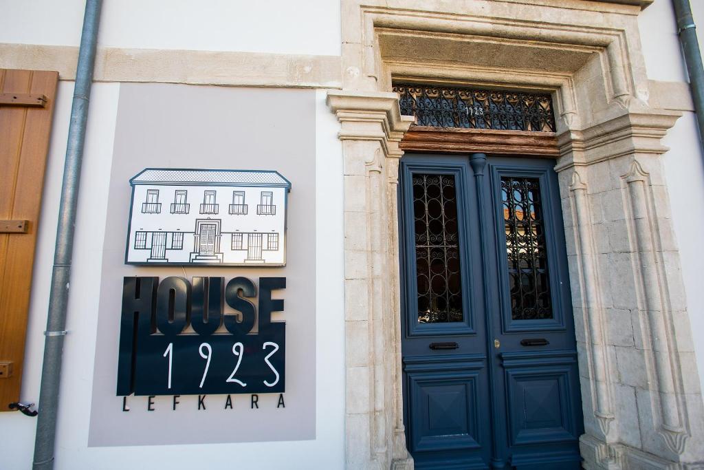 a building with a blue door and a house sign at House 1923 Boutique Hotel in Pano Lefkara