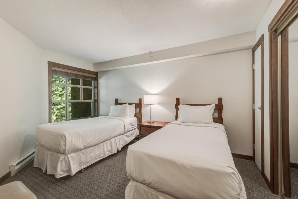a room with two beds and a window at Blackcomb Springs Suites by CLIQUE in Whistler
