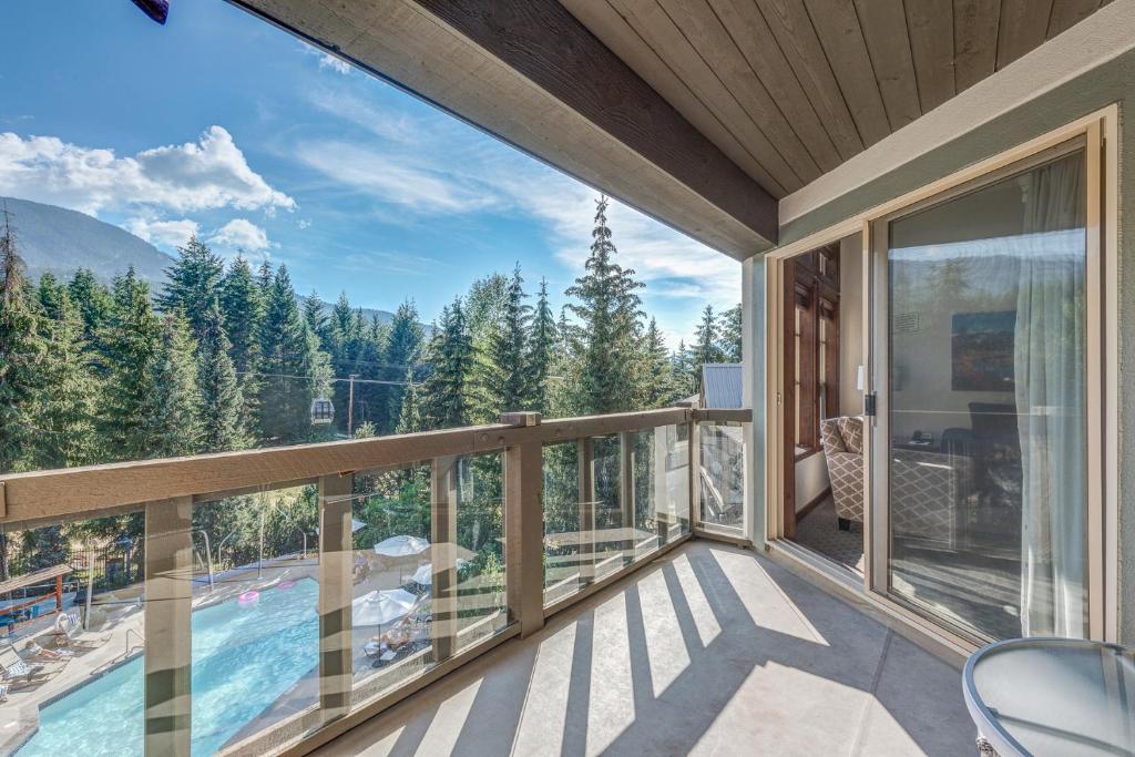 a balcony with a view of a pool and mountains at Blackcomb Springs Suites by CLIQUE in Whistler