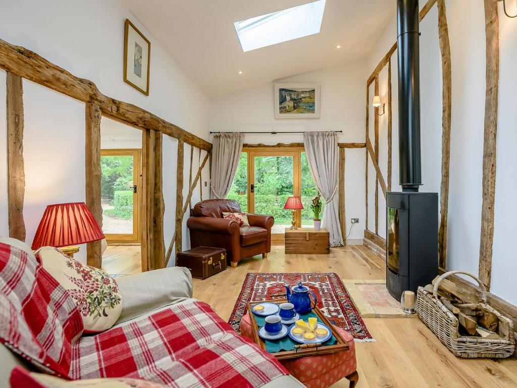 a living room with a couch and a wood stove at Barn End Cottage in Kelsale