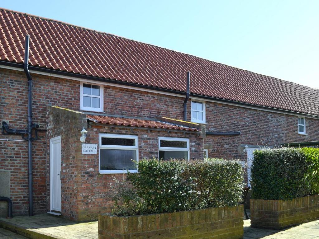 una casa de ladrillo con techo rojo en Granary Cottage - Uk10994 en Eshott