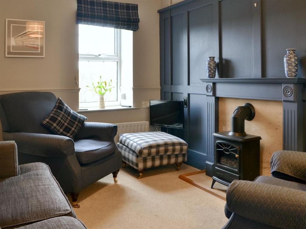 a living room with a chair and a fireplace at Secret View Cottage in Terrington