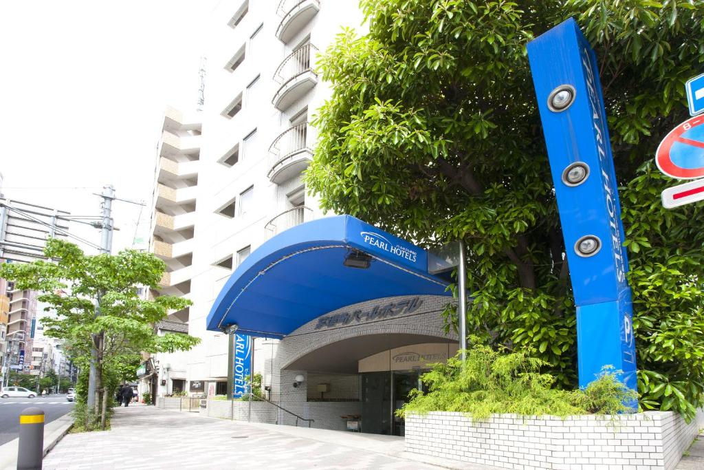um sinal azul na lateral de um edifício em Pearl Hotel Kayabacho em Tóquio