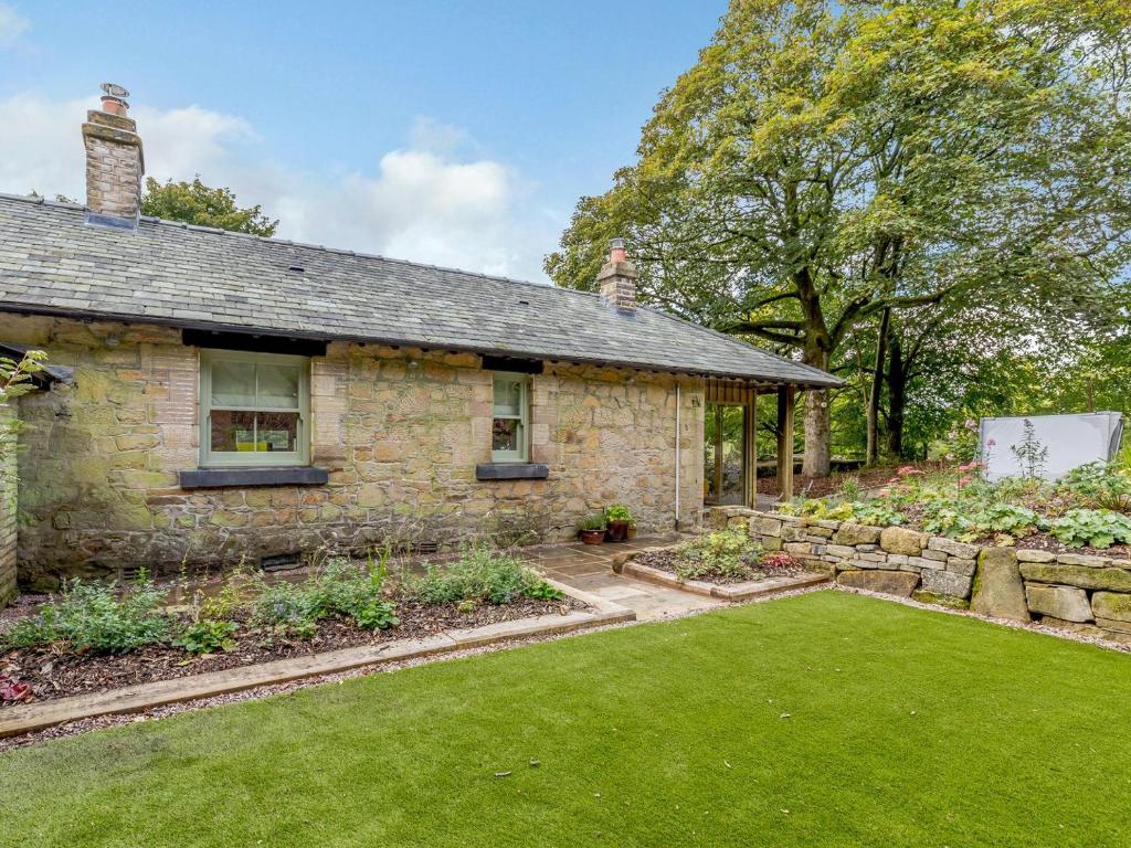 a stone house with a garden in front of it at Gadley Cottage - Uk31490 in Buxton