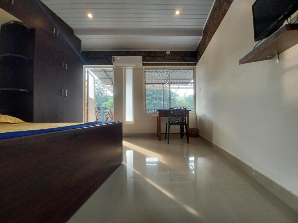 a bedroom with a bed and a table and a window at JEENA MOTEL in Kollam
