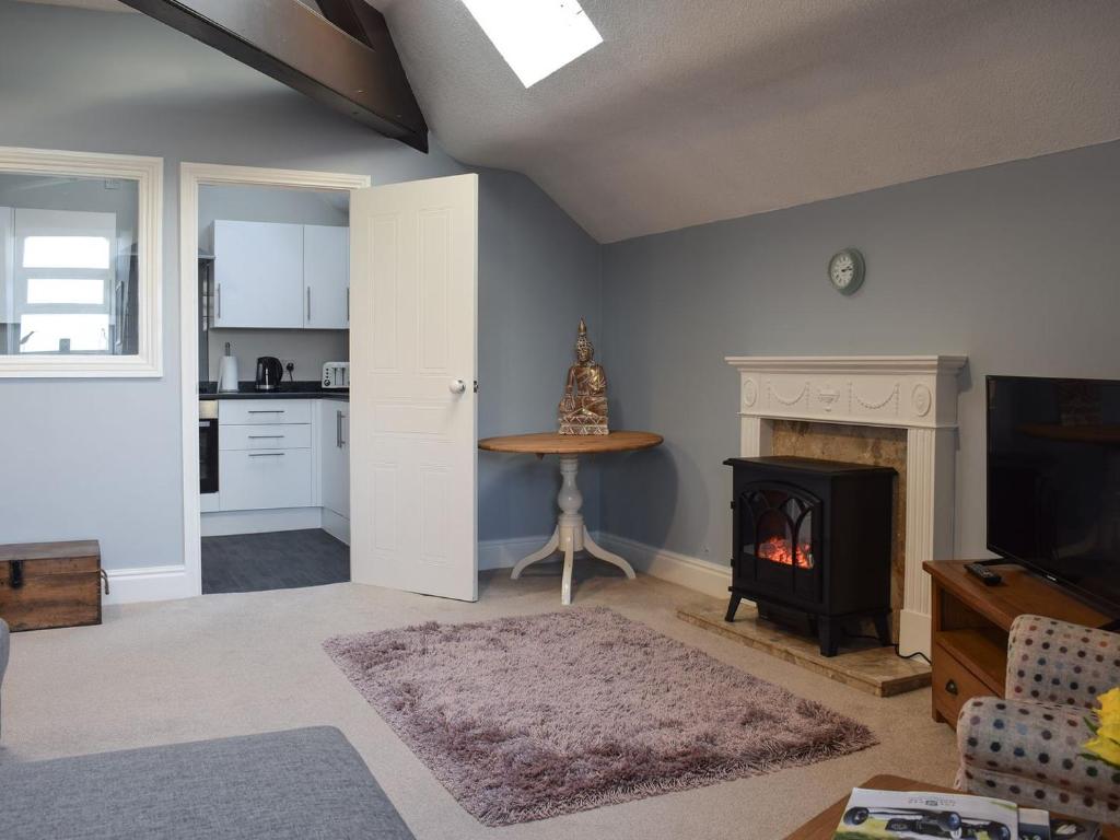 a living room with a fireplace and a kitchen at Skylight in Saltburn-by-the-Sea