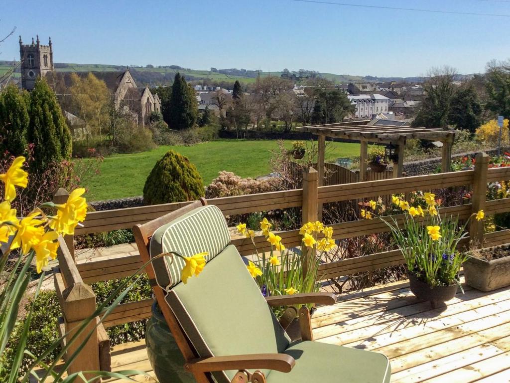 a wooden deck with a chair and flowers on it at Town View in Burneside