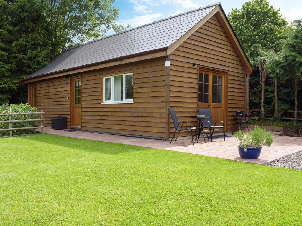 a small cabin with a table and chairs in a yard at Walkers Lodge in Hampton Bishop