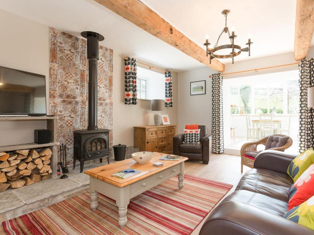 a living room with a fireplace and a wood stove at The Barn - Uk2475 in West Witton