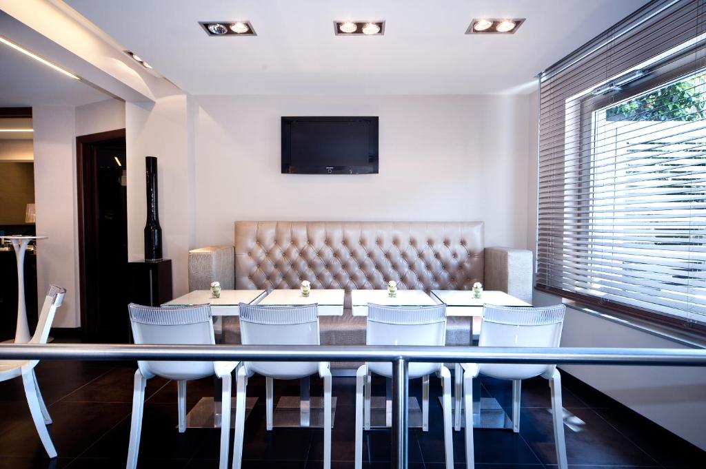 a dining room with a table and white chairs at Hotel Carla in Levanto
