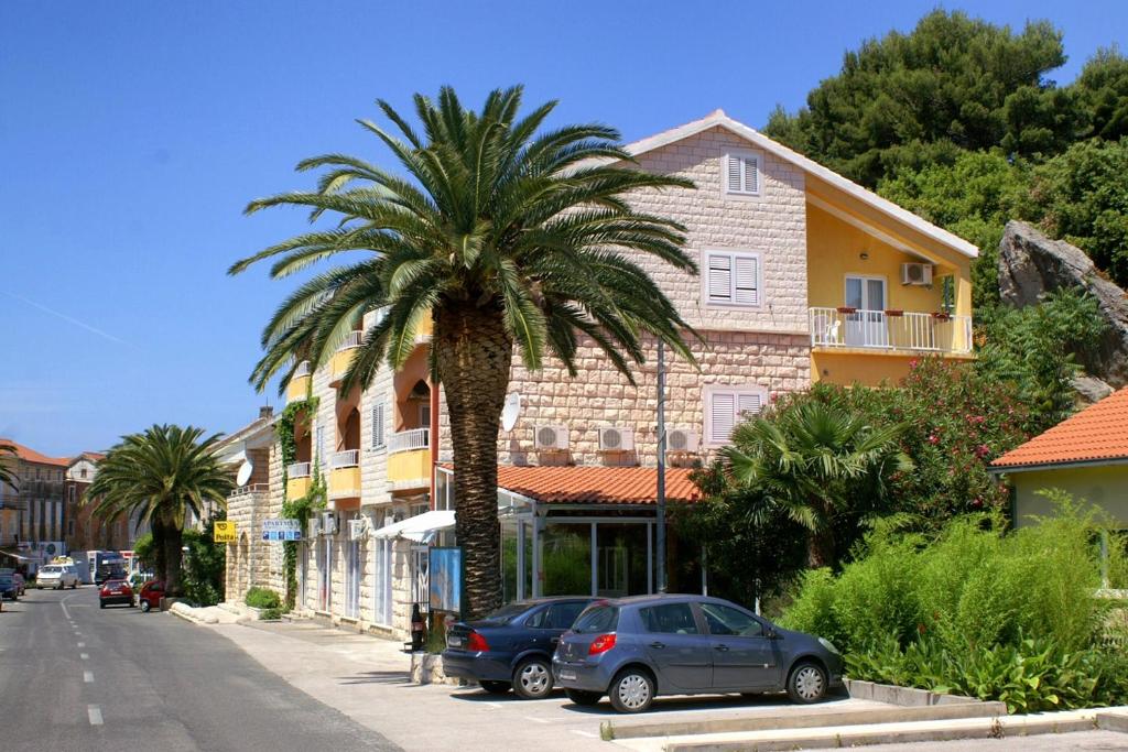 a palm tree on the side of a street at Apartments by the sea Trpanj, Peljesac - 3162 in Trpanj