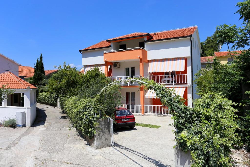 a house with a car parked in a driveway at Apartments by the sea Trpanj, Peljesac - 3157 in Trpanj