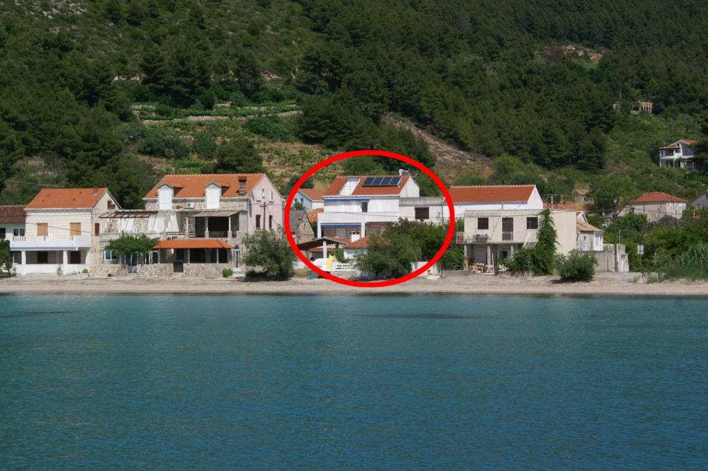 a red circle on a group of houses near the water at Rooms by the sea Zuljana, Peljesac - 3163 in Žuljana