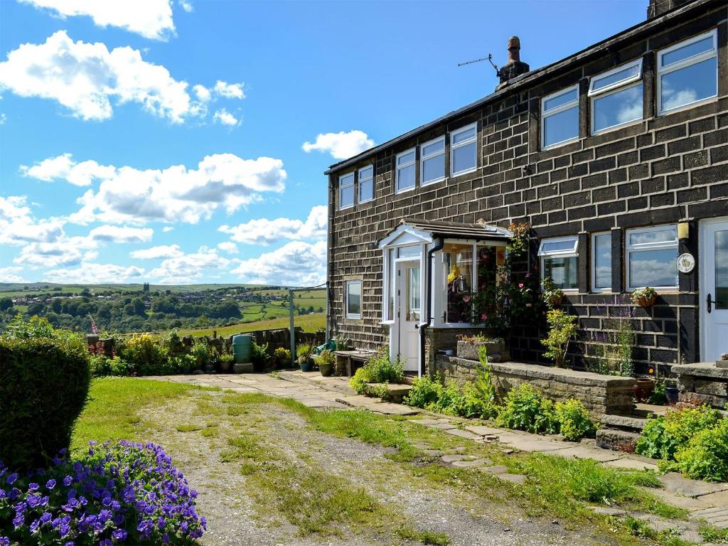 a brick house with a garden in front of it at Club House in Hebden Bridge