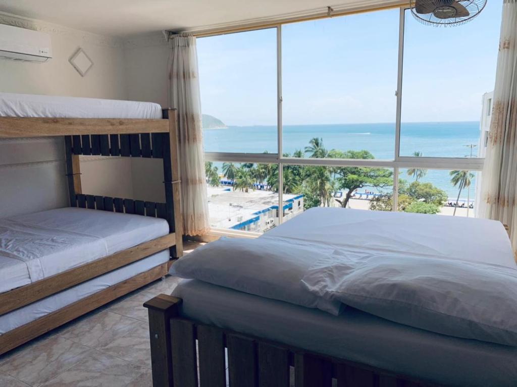 a bedroom with two bunk beds and a view of the beach at Luna Azul Rodadero apartaestudios in Santa Marta