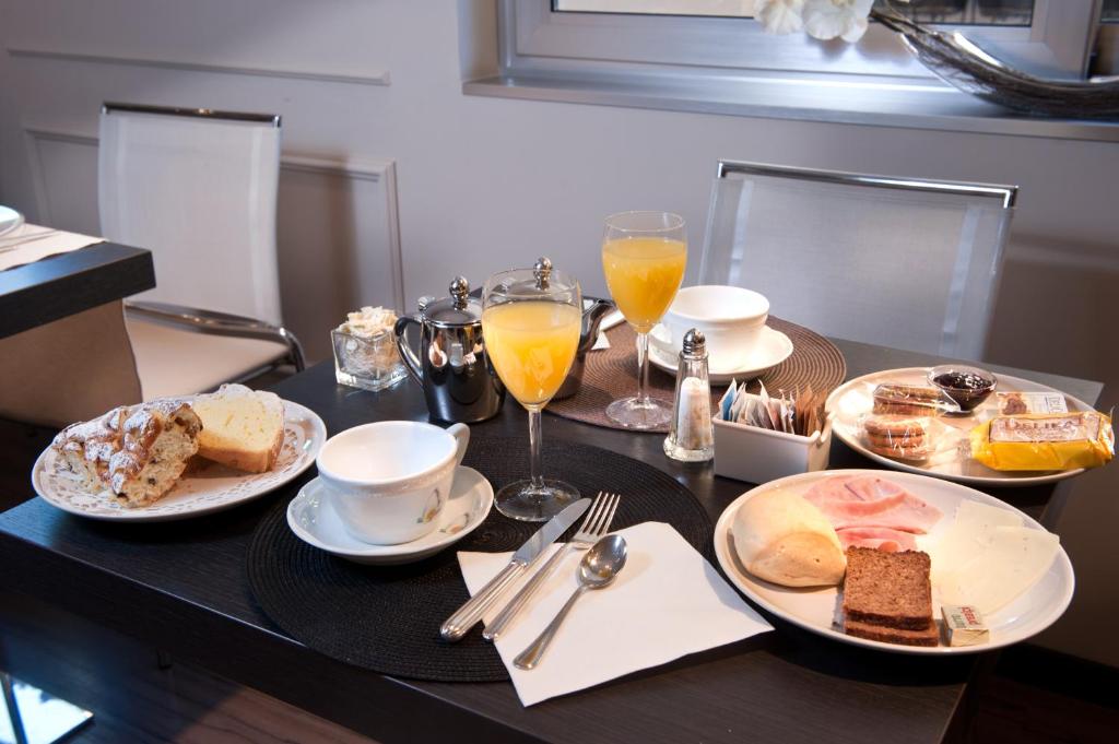 a table with plates of food and glasses of orange juice at Hotel Carla in Levanto