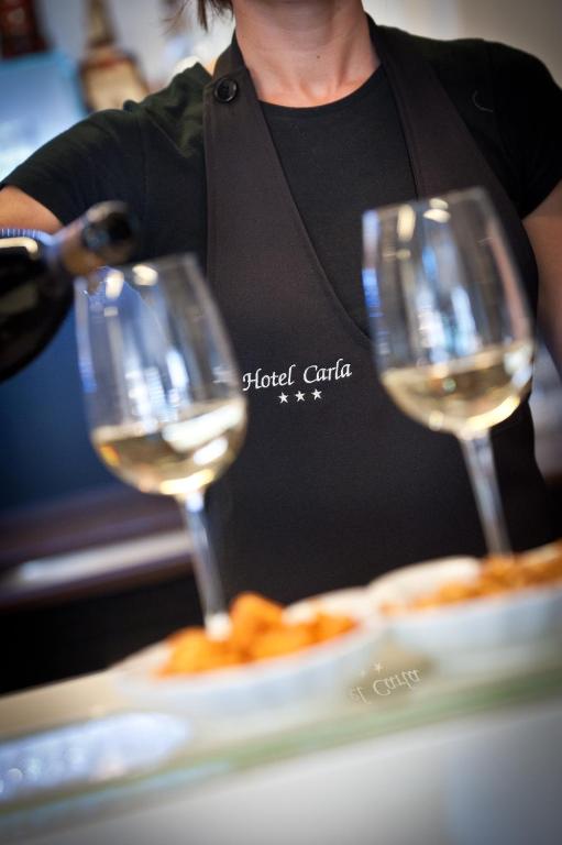 two glasses of white wine sitting next to a plate of food at Hotel Carla in Levanto