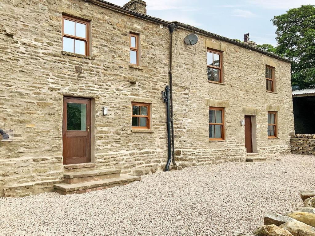 an old stone building with a door and windows at The Wool Loft - Uk31410 in Outhgill