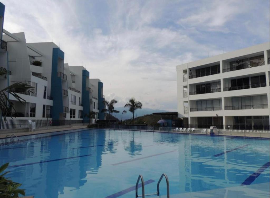 una grande piscina di fronte a due edifici di Aloja-T en Apartamento amoblado en Condominio de San Jeronimo a San Jerónimo