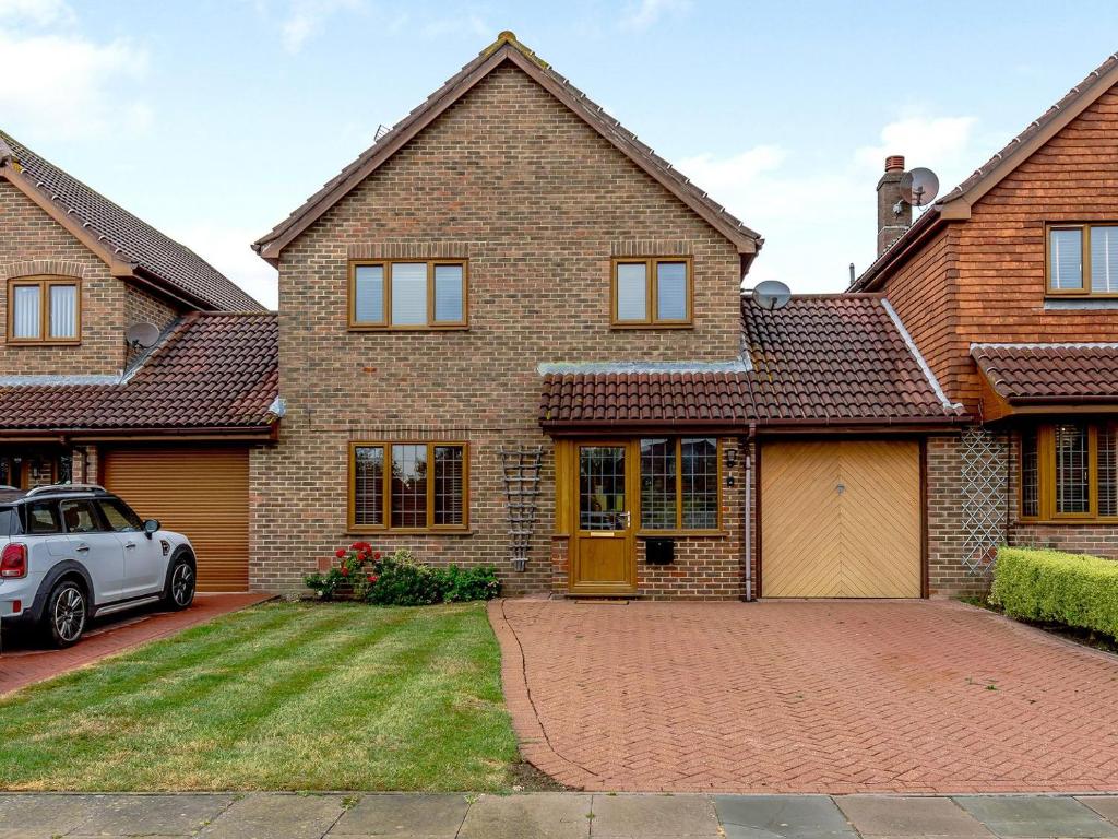 a brick house with a car parked in the driveway at Old Mead House in Folkestone