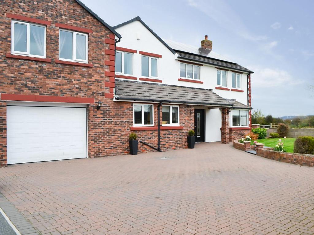 a brick house with two white garage doors at Chapel House in Dearham