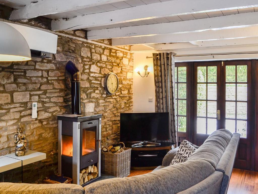 a living room with a couch and a fireplace at The Cart House in Merthyr Cynog