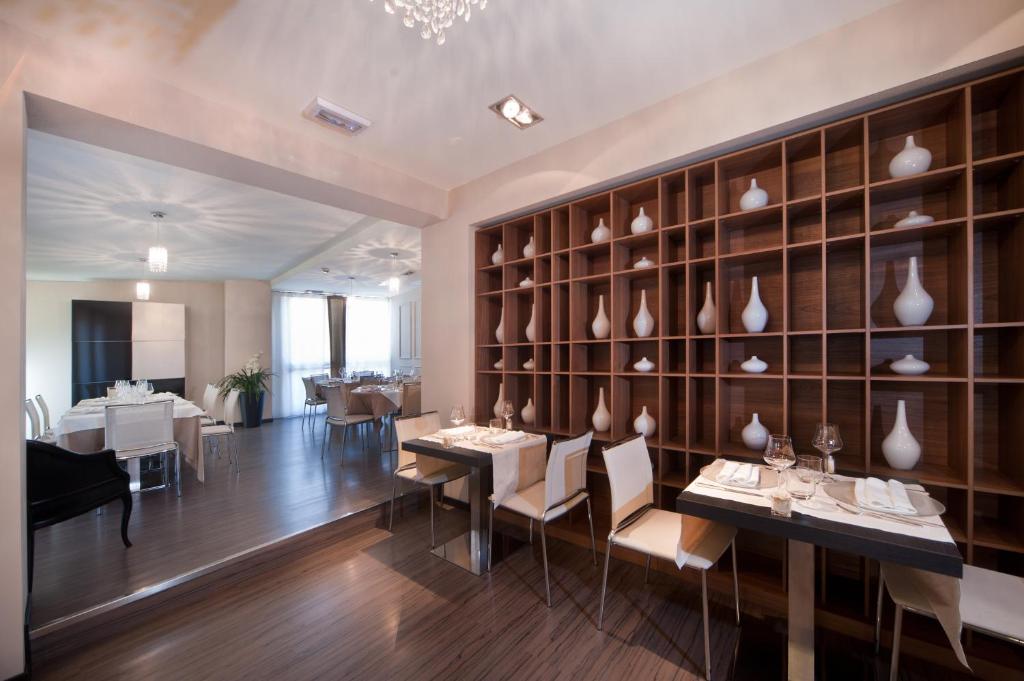 a room with tables and chairs and a wall with vases at Hotel Carla in Levanto