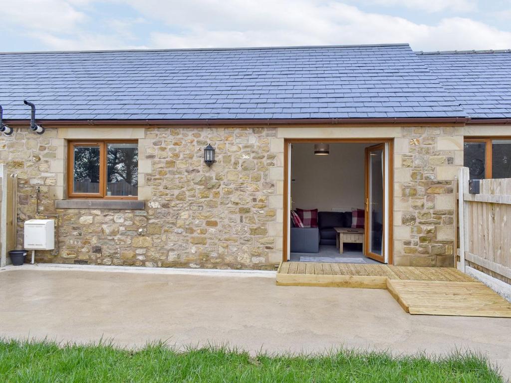 a stone cottage with a patio in front of it at Four Dorchester Drive - Uk32042 in Inglewhite