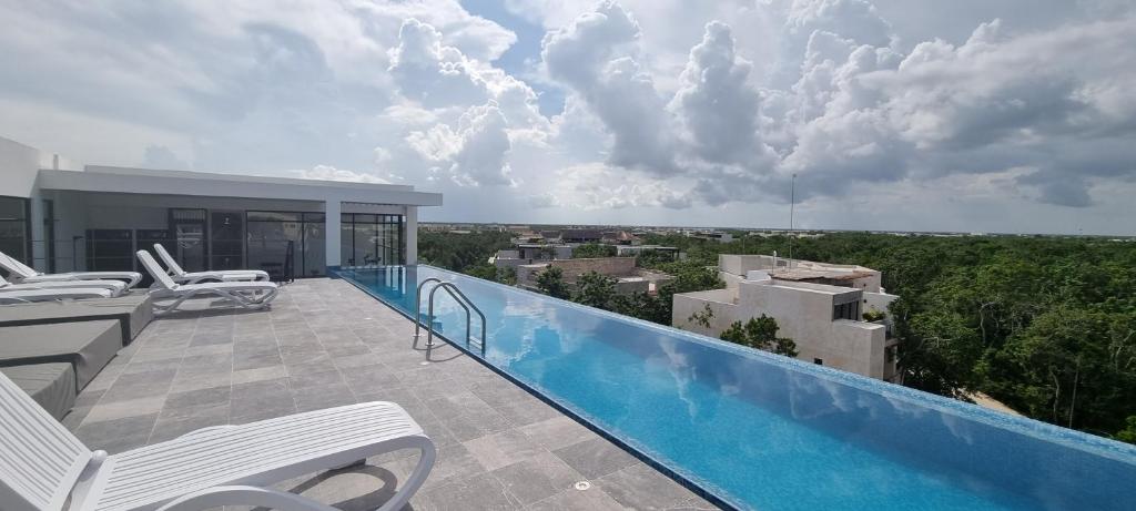 un balcon avec des chaises et une piscine dans l'établissement Acogedor estudio 305 wifi netflix Tulum Aldea Zama, à Tulum