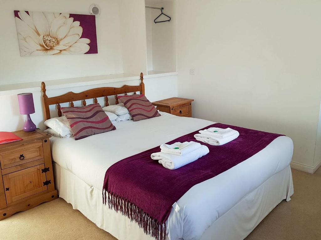 a bedroom with a large bed with towels on it at The Dolphin - Uk31004 in Avoch