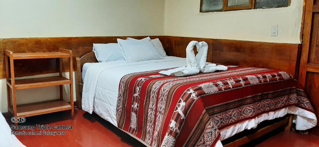 Un dormitorio con una cama con una toalla. en Hostal sambleño cusco Piero suite, en Cusco