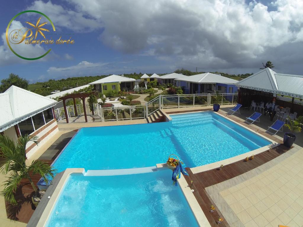 une grande piscine en face d'un complexe dans l'établissement La Palmeraie Dorée, à Saint-François