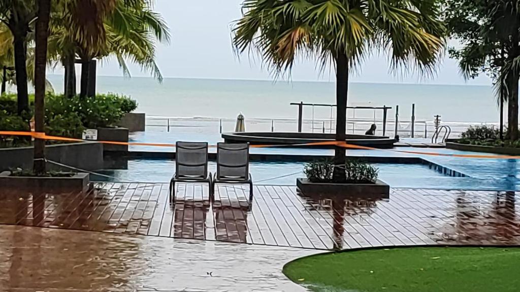 einen Pool mit zwei Stühlen und einem Boot in der Unterkunft Timur Bay by Dream View Studio in Kuantan