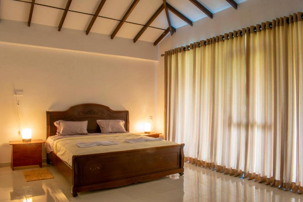 a bedroom with a bed and a large window at Pinnawala Elephant Front View Hotel in Rambukkana