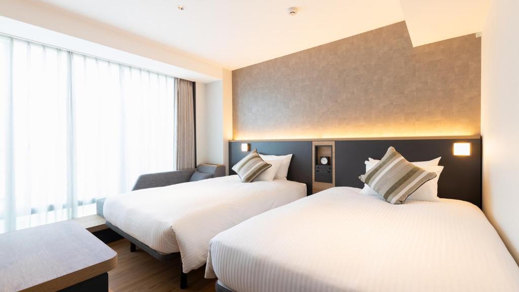 Postel nebo postele na pokoji v ubytování JR-East Hotel Mets Yokohama