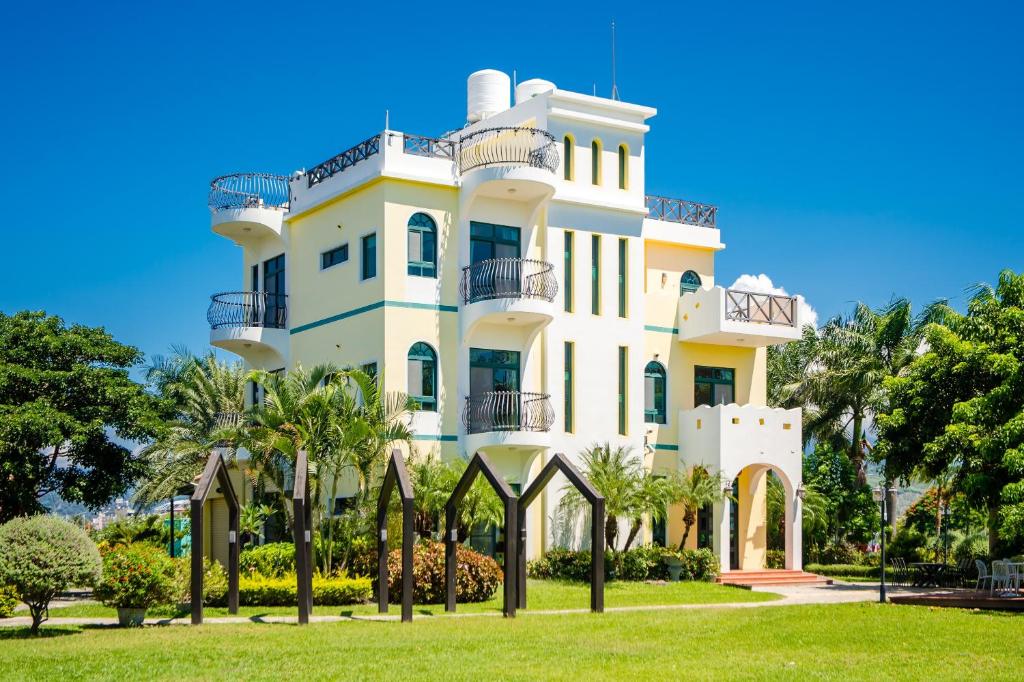 a white building with trees in front of it at Summer Garden in Taitung City