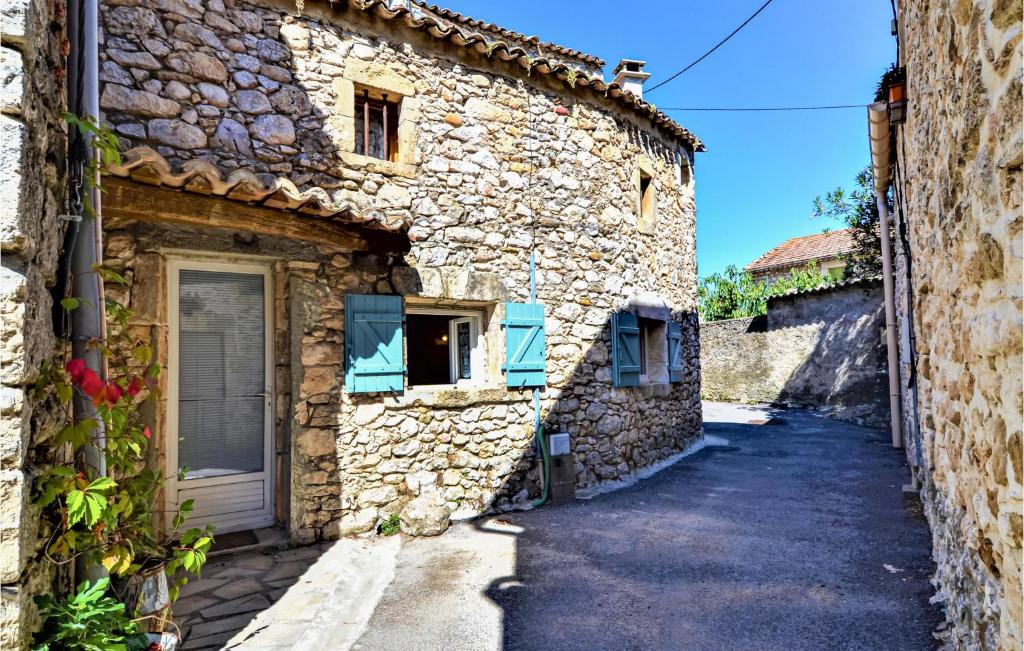 una casa de piedra con persianas azules en una calle en Amazing Home In Goudargues With Kitchen, en Goudargues