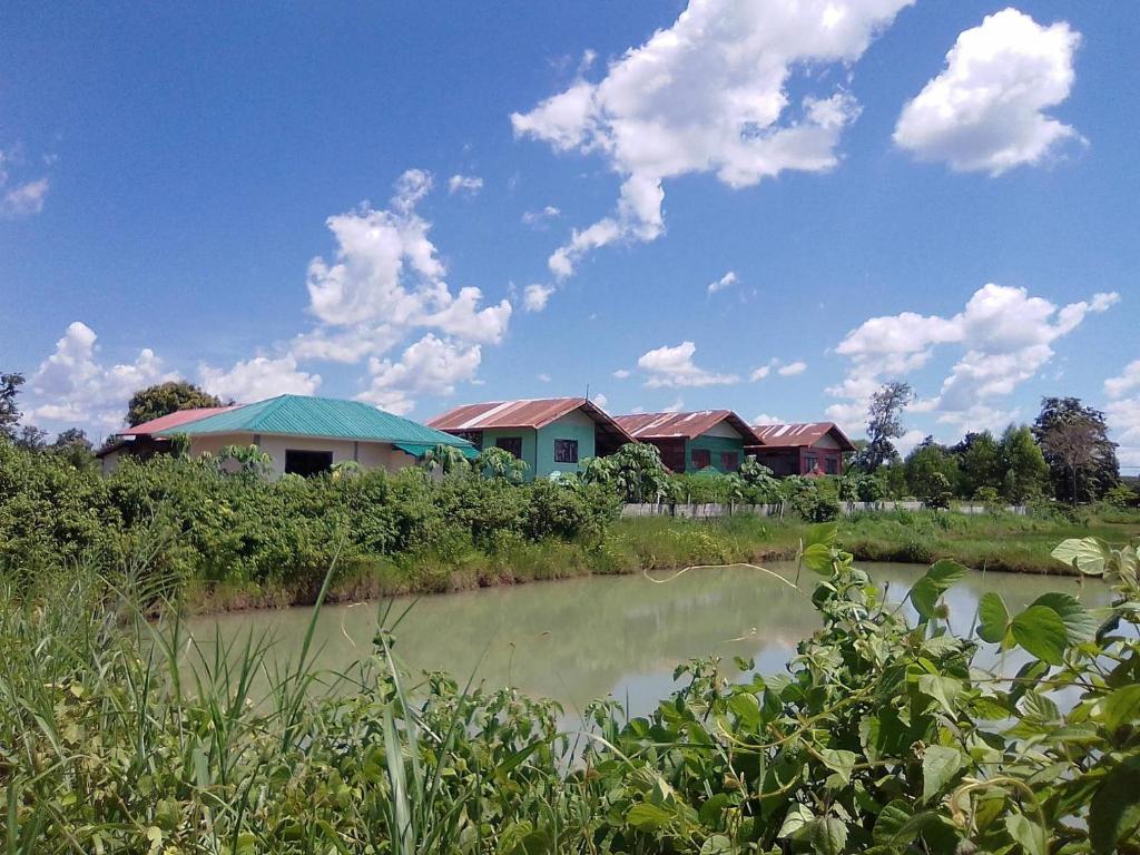 a group of houses next to a river at Lek's Issan Home and Travel in Ban Kut Khaen
