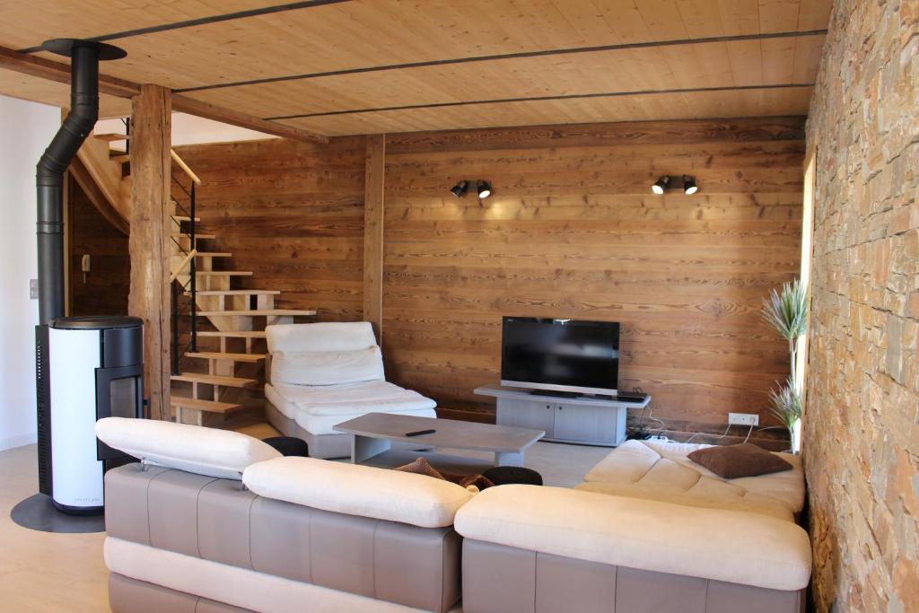 ein Wohnzimmer mit 2 Sofas und einem TV in der Unterkunft grand appartement privé neuf avec loggia in Orchamps-Vennes